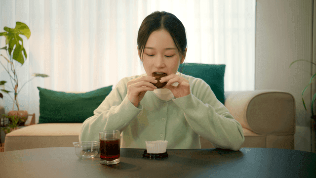Woman eating dujonku with coffee