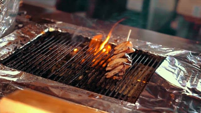 불꽃 그릴 위에서 구워지는 맛있는 꼬치 구이