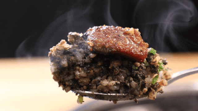Spoonful of stone pot rice topped with steaming marinated beef short ribs