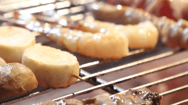 Various skewers grilling on a barbecue