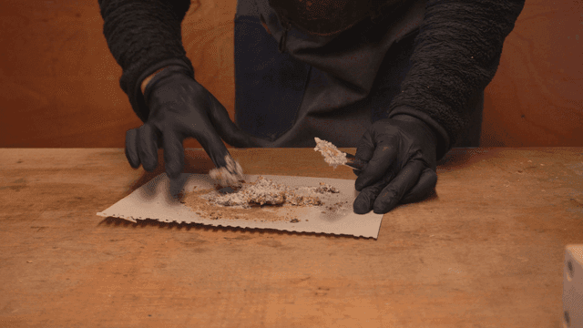 작업대에서 톱밥에 본드를 혼합하는 목공