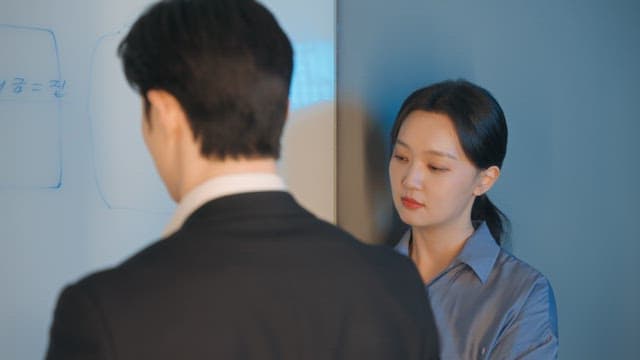 Two colleagues discussing at a whiteboard