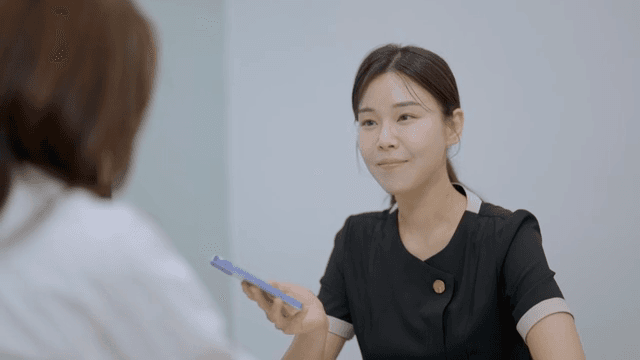 상담실에서 사진을 보여주며 상담을 받는 여성