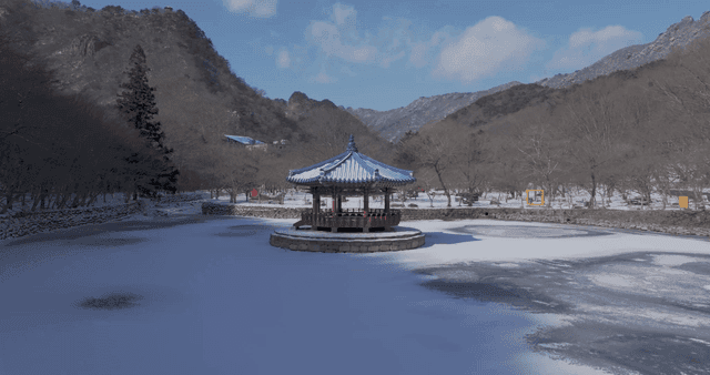 Snow-covered pavilion and frozen lake