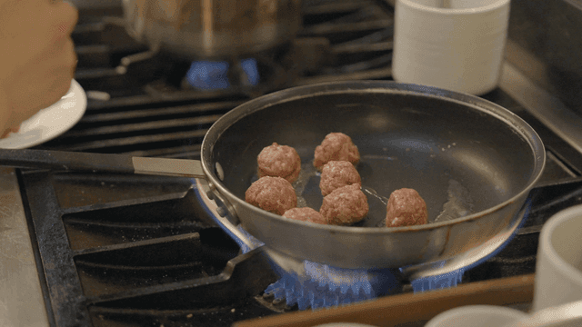 Meatballs cooking in a frying pan