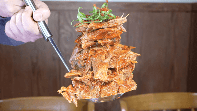 Ladle lifting full bowl of pork backbone stew