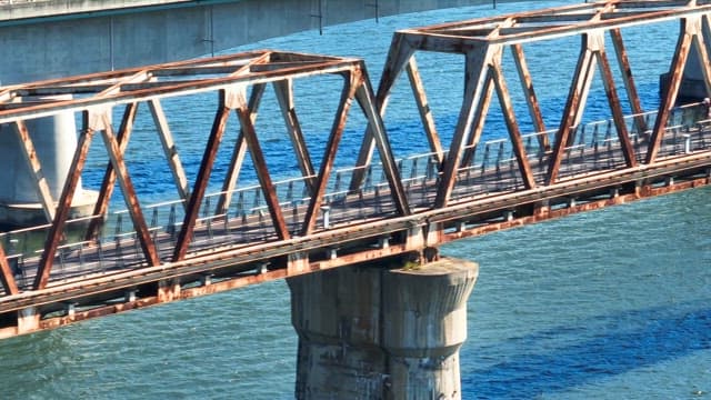 People cycling on a bridge over a river