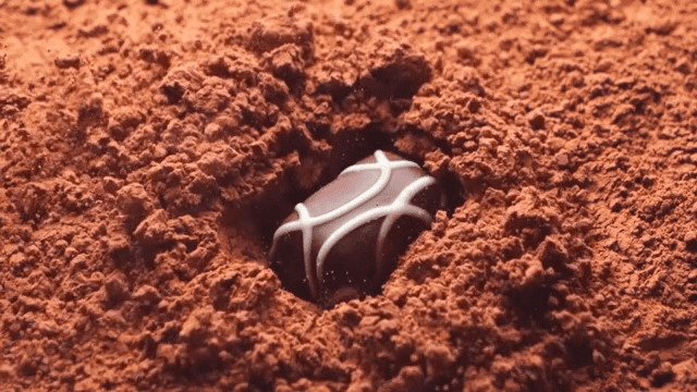 Chocolate falling onto cocoa powder in slow-motion