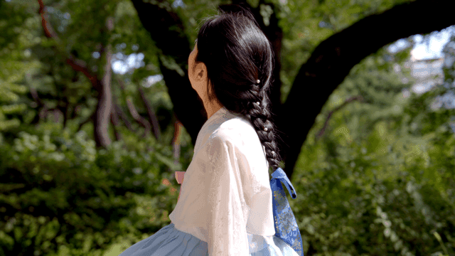 Woman in traditional Korean attire outdoors