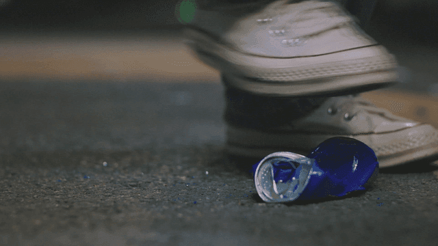 길거리에서 파란색 캔을 밟는 사람