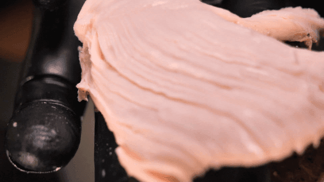 Close-up of raw chicken being handled