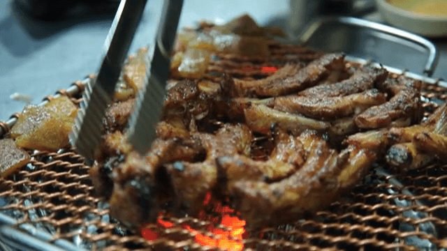 Grilled galbi sizzling on a hot grill