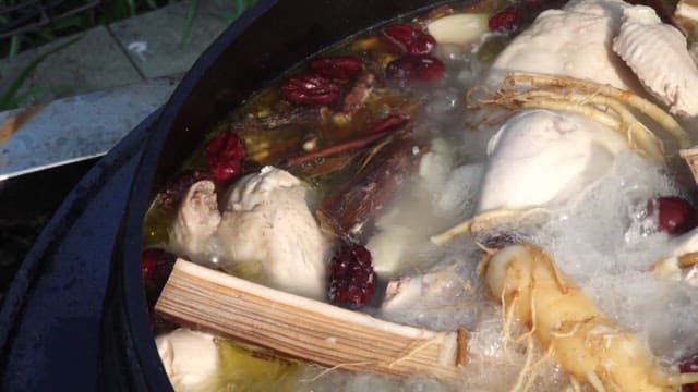 Ginseng Chicken Soup with ginseng and jujubes boiling in a cauldron