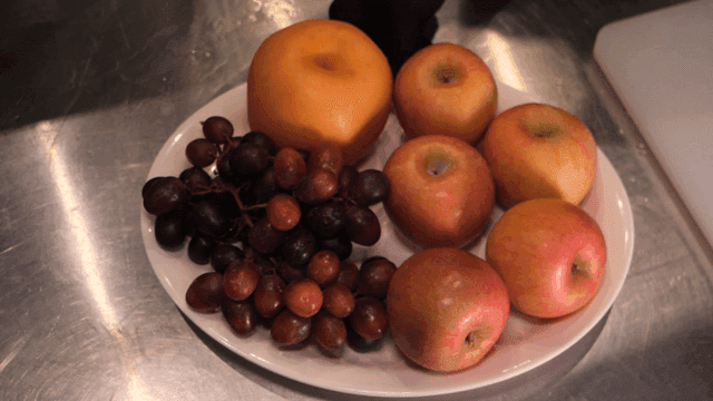 A plate of fresh fruits on a kitchen counter