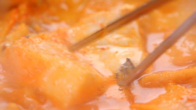 Fish picked with chopsticks from boiling codfish soup