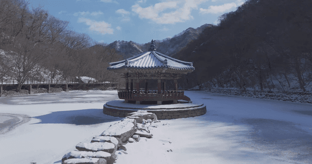 Snow-covered Hanok pavilion in tranquil winter landscape