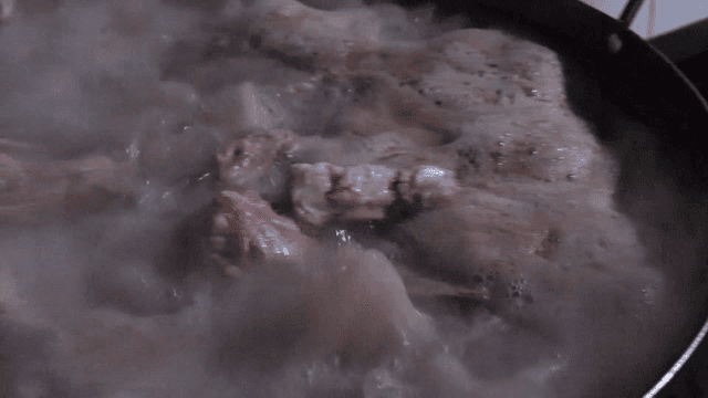 김이 나는 냄비에서 끓고 있는 고기