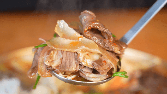 Ladle full of beef stew with vegetables