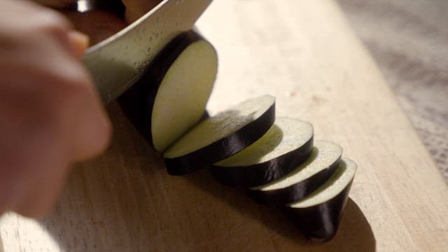 Slicing an eggplant on a wooden board