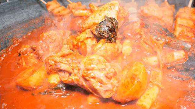 Boiling spicy chicken stew in cast iron pot