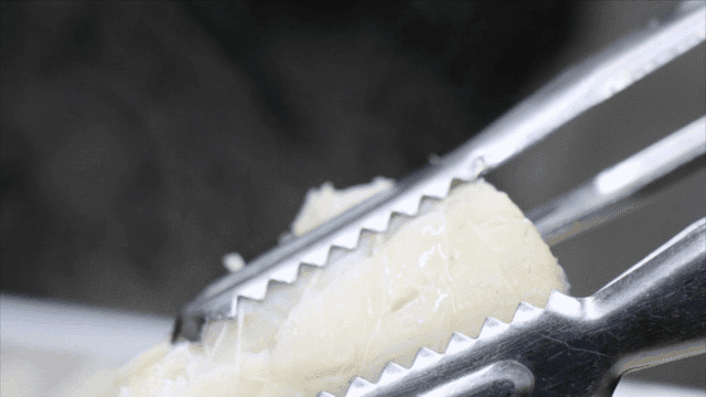 집게로 잡은 익힌 대구탕 조각