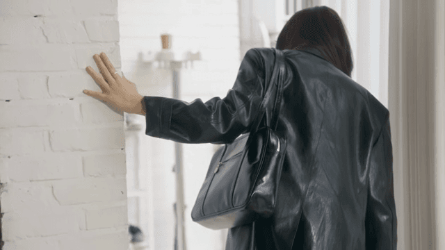 급하게 신발을 신고 문 밖을 나서는 여성