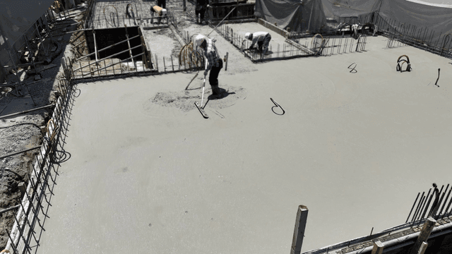 건설 현장에서 콘크리트를 고르는 작업자들