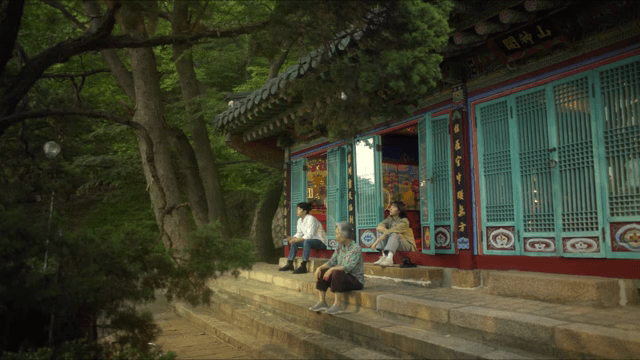 사람들이 전통 사원 밖에 앉아 있는 모습