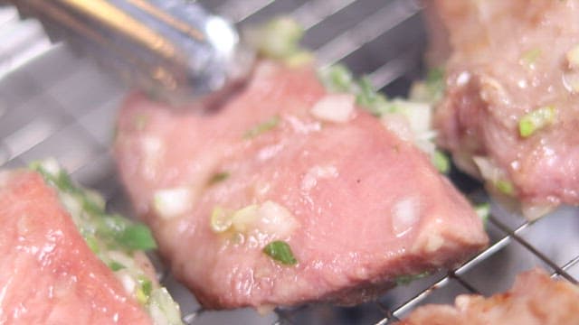 연기가 자욱한 그릴 위의 지글지글 구워진 고기