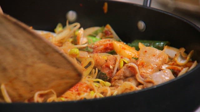 철판에서 나무 주걱으로 요리되는 콩나물 불고기