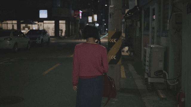 Frustrated woman walking alone on a city street at night
