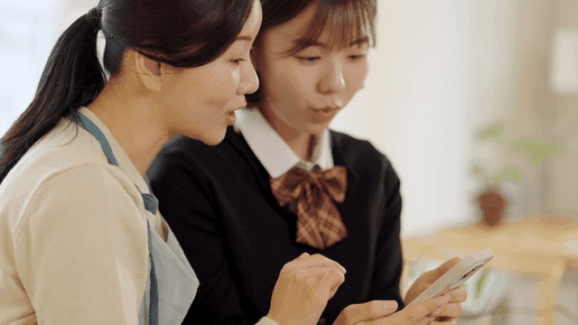 Two women looking at a smartphone together