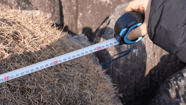 Measuring tape on rocky surface