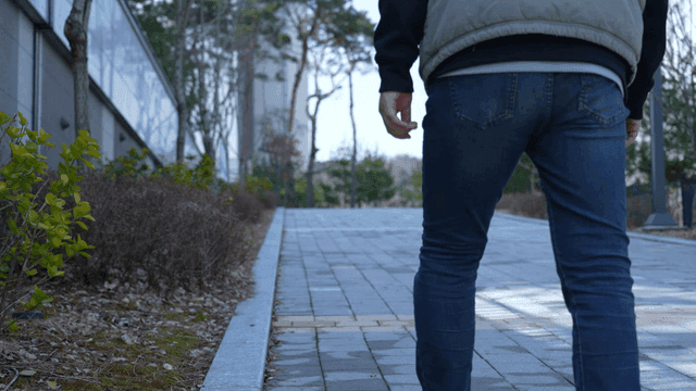 Back of man walking down quiet apartment complex street