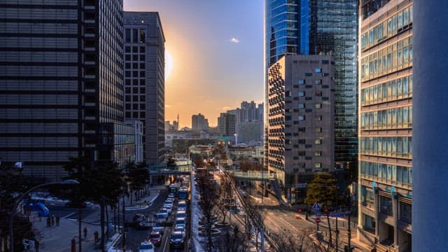 Busy city street during sunset transitioning into night