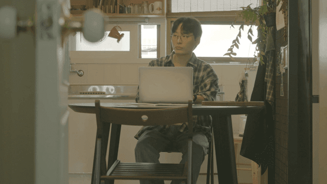 아늑한 주방에서 노트북으로 일하다 일어서나는 남자