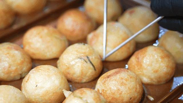 Takoyaki being cooked on a hot plate