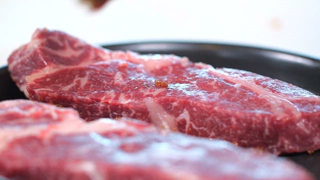 신선한 스테이크용 소고기에 양념을 바르는 모습