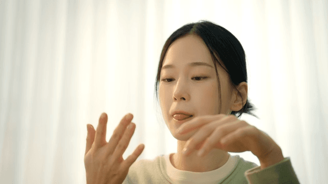 Young woman sucking her thumb at home