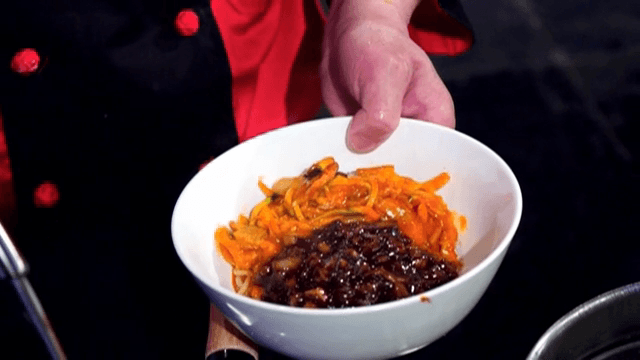 Putting Black Bean Sauce on top of Spicy Seafood Noodle Soup