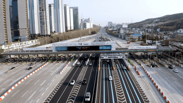 Busy highway toll gate with high-rise buildings
