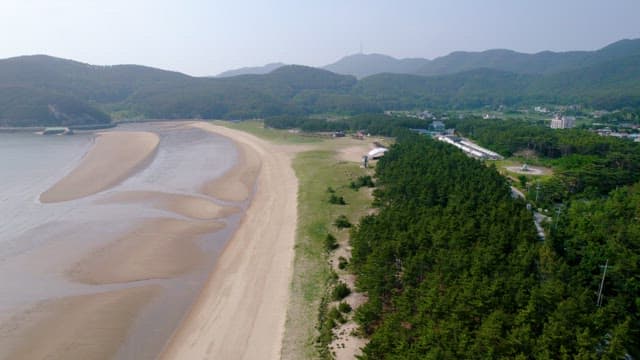 Wet Sandy Beach and Secluded Coastal Village Landscape