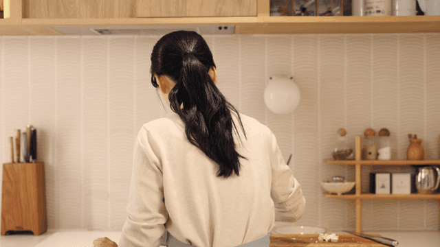 Back view of woman preparing food in kitchen