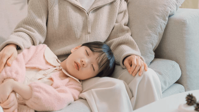 소파에서 부모의 무릎에 누워 잠든 아이