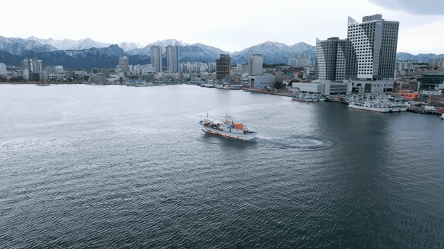 해안 도시 근처를 항해하는 배