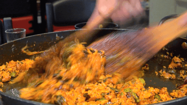 나무 주걱으로 빠르게 볶아지는 철판 볶음밥