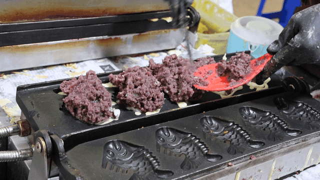 Batter in fish-shaped mold receiving red bean filling
