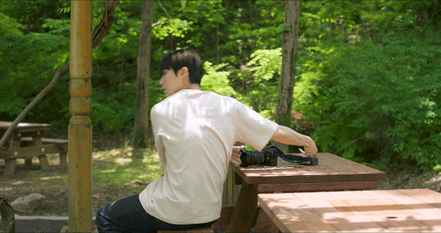 숲속 공원 벤치에 카메라를 두고 뛰쳐나가는 남성