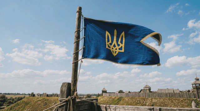 Ancient Ukrainian flag fluttering near historic fortress