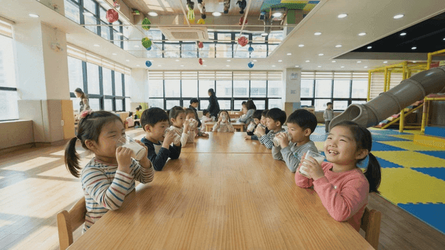 Children drinking milk in bright kindergarten